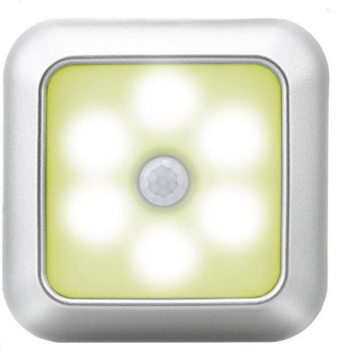 The puck light lit warm, showing its six LEDs around the central motion sensor