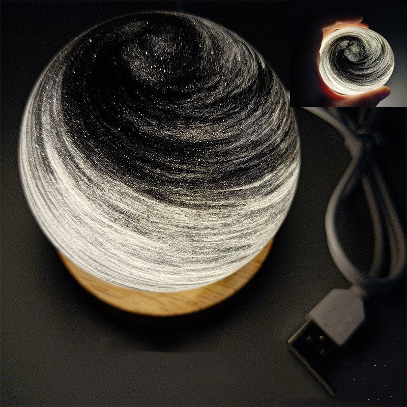 Planet night light in Night, a marbled glass globe lit warm on a wooden base